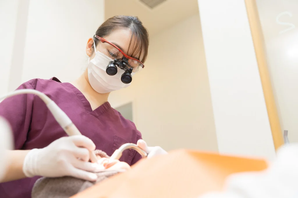 口腔内の治療を行う女性スタッフ