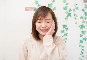 頬を抑える女性